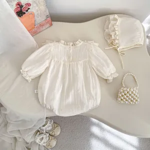 Detailaufnahme von Baby-Strampler aus Baumwoll-Crepe mit Blumenstickerei und Rüschen