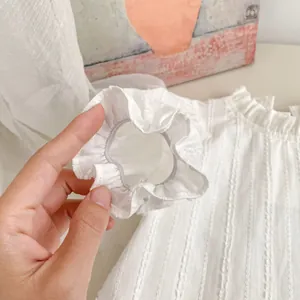 Detail of white ruffled elastic cuffs with textured fabric on long-sleeved girl shirt