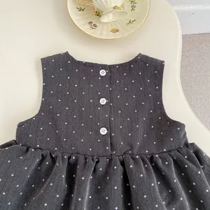 Detalle de vestido sin mangas a lunares para bebé con botones en la espalda
