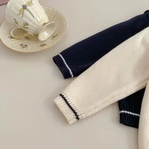 Close-up of knit sweater cuffs with contrast stripes and detailed fabric texture