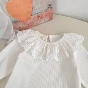 Vista de detalle de la camiseta blanca de punto con cuello de encaje bordado para niñas