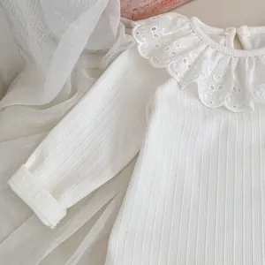 Detalle de camiseta de algodón acanalado para niña en blanco roto con cuello de encaje