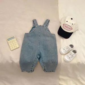 Dettaglio salopette in denim azzurro per neonato con polsini elastici e tessuto in cotone morbido