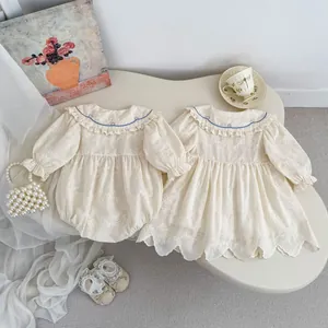 Détail de barboteuses pour bébé avec broderie florale et col Claudine bleu de style français