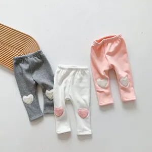 Detailed close-up of winter baby leggings with plush heart patches and elastic waistband