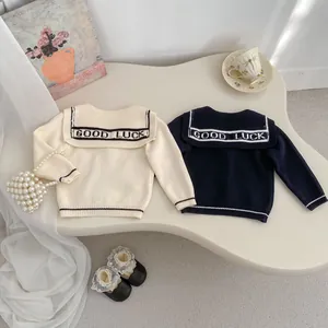 Detailed knit texture of girl's navy collar cardigan with GOOD LUCK lettering
