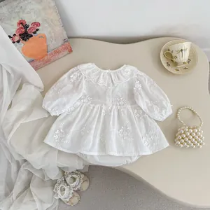 Detailed view of white floral embroidery and lace Peter Pan collar on infant girl dress