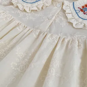Détail de la broderie florale sur barboteuse en coton avec col Claudine pour bébés filles
