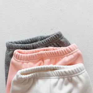 Close-up detail of elastic waistbands on gray pink and white baby fleece leggings