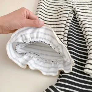 Detail of girls' flared knit pants with striped ruffle hem and textured fabric finish