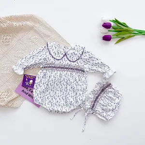 Detailed macro view of purple floral smocking embroidery on baby girl cotton bodysuit