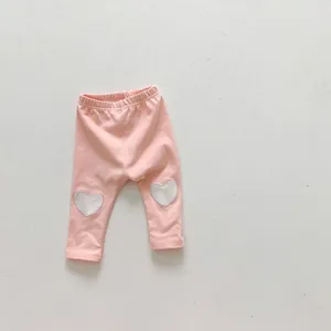Détail du pantalon rose en coton pour bébé avec empiècements aux genoux en forme de cœur