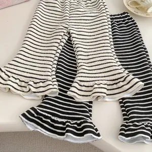 Detail view of elastic striped flare pants for girls featuring ruffle hems and textures