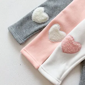 Detail of warm winter baby leggings showing velvet heart embroidery on various colors