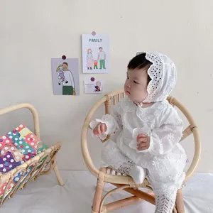 Detail of baby lace romper set with flower embroidery and matching sun hat in white