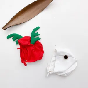 Detail of Christmas baby hats with reindeer antlers and pom-poms in soft knit fabric