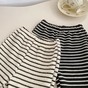 Detail of waffle textured striped kids pants with elastic waistband in two colors