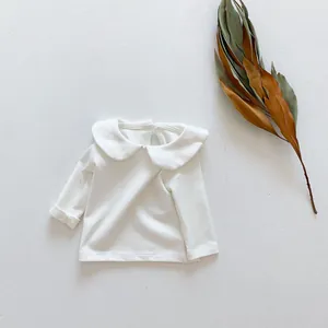 Detailweergave van wit baby-shirt met lange mouwen van katoen met klassieke Peter Pan kraag