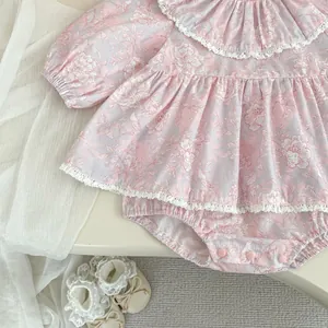 Dettaglio di pagliaccetto rosa a fiori con colletto in pizzo a balze e bottoni a pressione