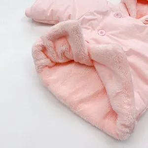 Detail view of pink baby coat featuring soft plush lining and round buttons
