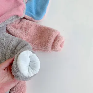 Detailed close-up of thickened plush baby romper showing soft coral fleece texture and cuffs