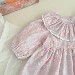 Dettaglio del vestito floreale per neonata con colletto in pizzo e maniche a sbuffo