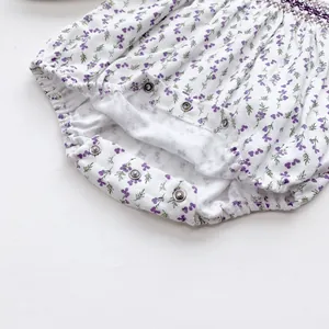 Detailed view of baby romper featuring purple floral print and metal crotch snap buttons