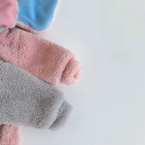 Detail showing plush fleece fabric textures in pink, grey and blue for baby rompers