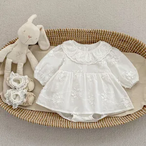 Detailed view of white floral embroidery and lace collar on infant cotton romper suit