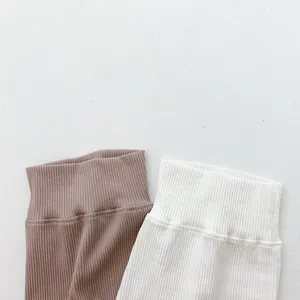 Detail of ribbed knit waistband on high-waist baby leggings in brown and white