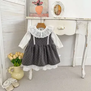 Detalle de blusa con cuello de encaje blanco y vestido gris de lunares con etiqueta 73