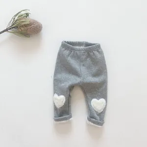 Close-up of grey baby leggings with heart knee patches and warm fleece lining