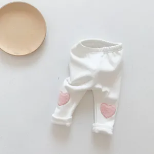 Detail of baby leggings in cream white with soft pink plush heart knee embroidery