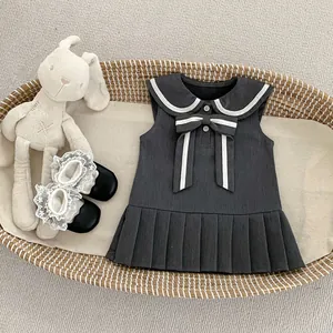 Detalle de vestido marinero gris para bebé con cuello blanco y lazo de contraste