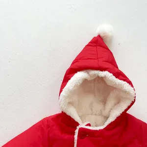 Detail of red baby winter coat featuring plush fleece lining and cute white pom-pom hood