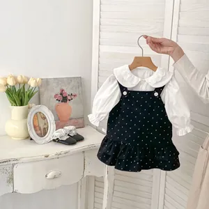 Dettaglio outfit bimba con colletto Peter Pan in pizzo e abito a pois con bretelle