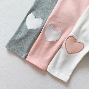 Détail de leggings bébé en coton avec broderie coeur et texture en maille douce