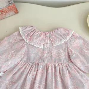Dettaglio body neonata a fiori con colletto in pizzo a balze e chiusura a bottoni