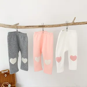 Detailed view of fleece infant leggings in grey pink and white with heart knee patches