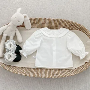 Dettaglio camicia bianca neonata in cotone con colletto in pizzo e polsini con volant
