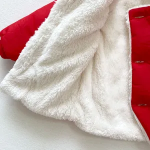 Detailed close-up of thick white lamb fleece lining on a red winter baby coat with buttonholes