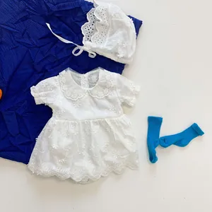 Close-up of baby girl summer romper dress with floral embroidery and lace hat