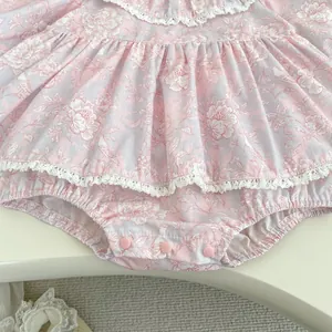 Dettaglio del body neonata a fiori con bordi in pizzo e chiusura a bottoni