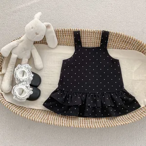 Dettaglio vestito a pois per neonata con spalline e balze sull'orlo inferiore
