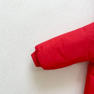 Detail of red winter jacket ribbed cuffs with matte texture and warm padded lining