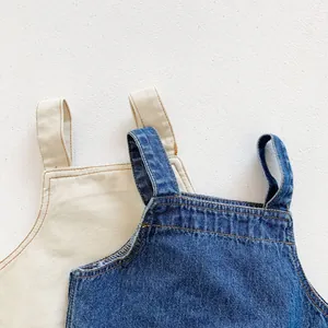 Detail of denim and canvas baby overalls showing high-quality stitching and fabric texture
