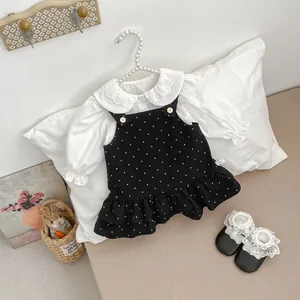 Dettaglio di camicia con colletto in pizzo e gonna a pois con etichetta taglia 73