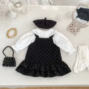 Dettaglio completo del set bambina retrò con abito a pois e camicia con colletto in pizzo
