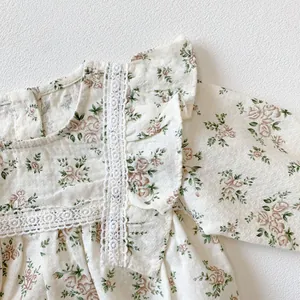 Detailed macro view of floral baby bodysuit featuring lace trim and ruffled cuffs