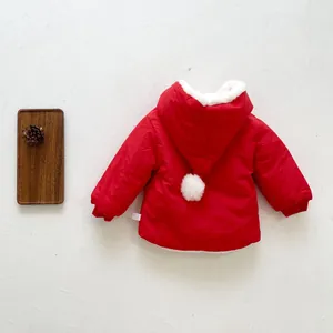 Detailed view of red winter baby jacket featuring soft faux fur lining and white pom-pom hood